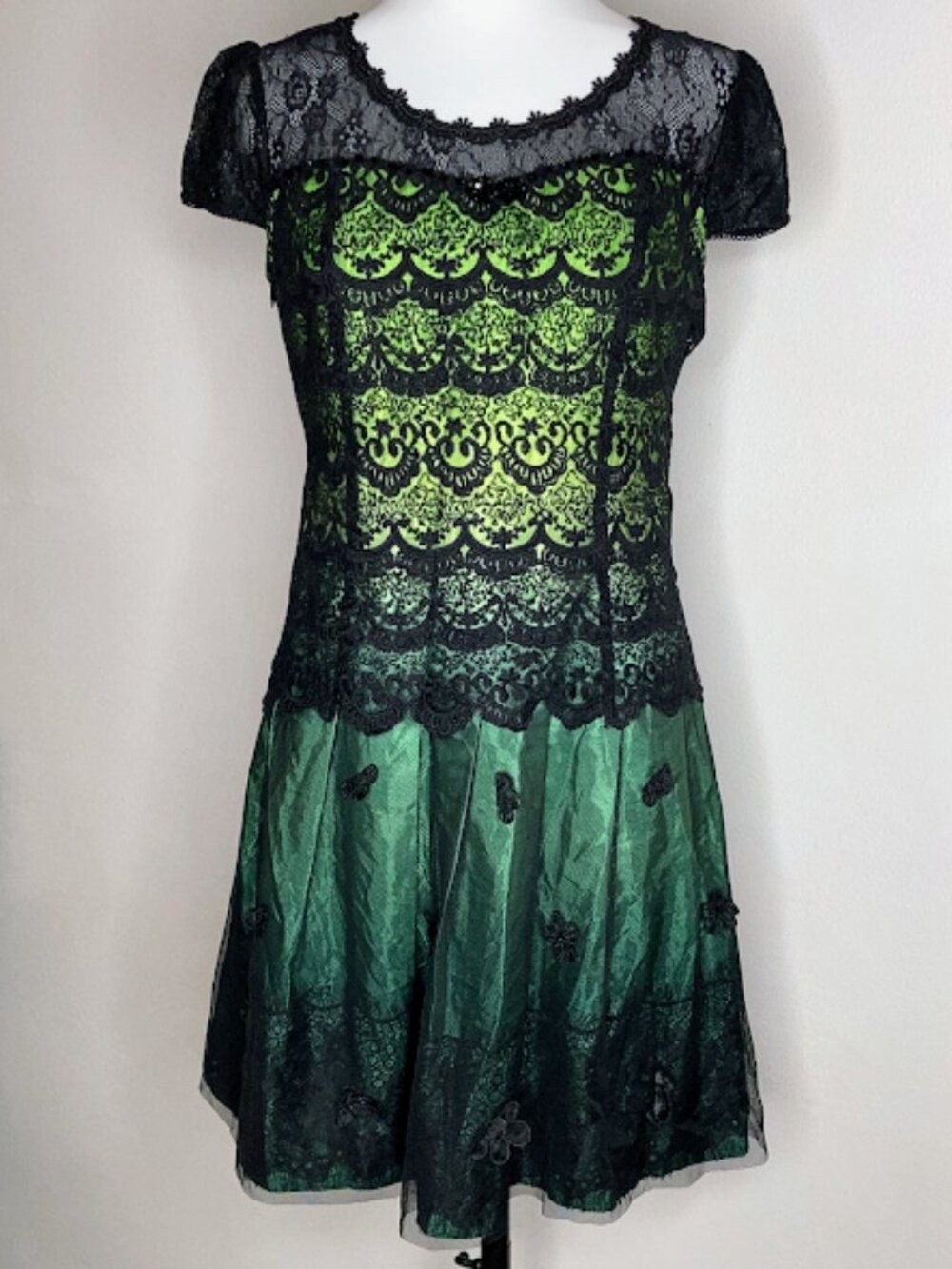#66904 sleeved jumpsuit with a green lining and black lace overlay